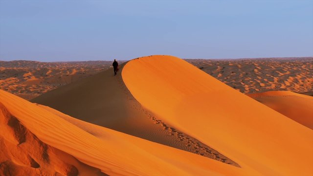 Sahara Desert landscape. Sif Es Souane big dunes. A man walking on dunes.