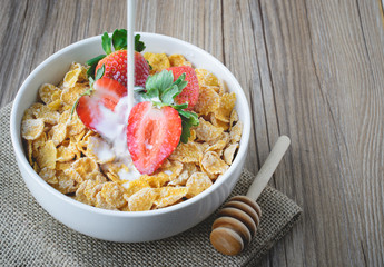 Cereal Conrflakes with strawberry on wood