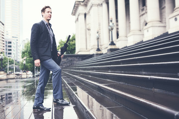 Young business man climbing steps on way to work horizontal