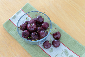 Cherries in glass bowl on wooden table