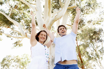 Young couple in the park celebrating