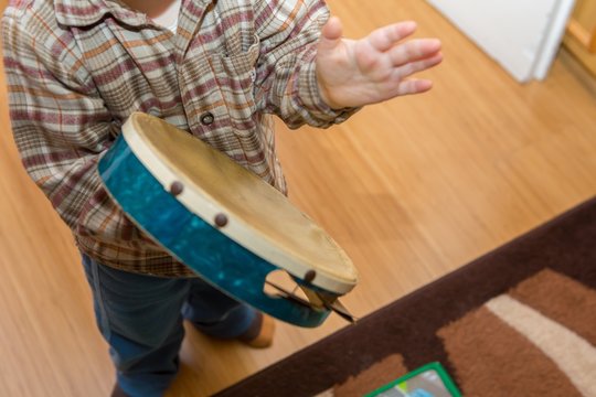 Small Child Playing On Drum