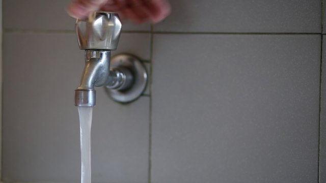 hand closing the tap water drinkable