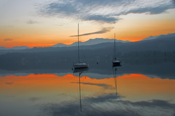 Barche sul lago con i colori del tramonto