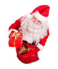 Santa Claus holding Christmas bag with gift box and looking up to camera