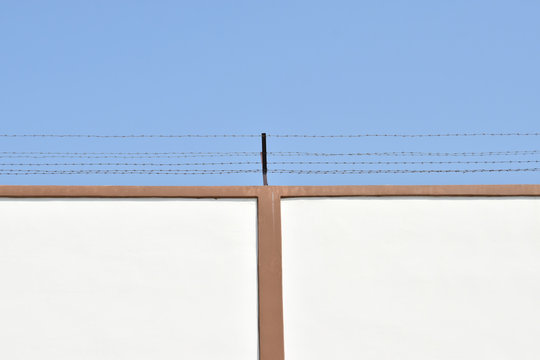 Prison wall and wire barbs