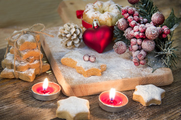 Christmas background with christmas gingerbread cookies and candles on wooden