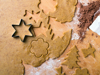 Cookies forms and gingerbread dough on wooden pastry board