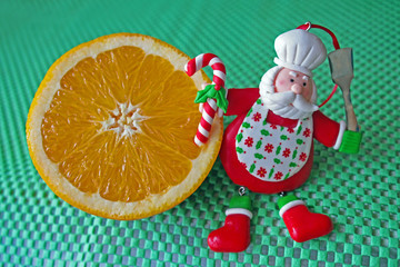 Christmas - green background, poinsettia, orange and funny chef Santa Claus