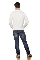 handsome young man posing in jeans from the back