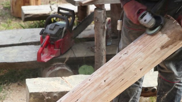 Carpenter polishing timber wood using electric grinder; real people, real life; 