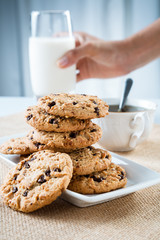 close up of cooking and hand holding glass of milk
