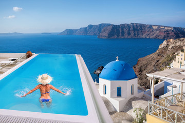 Santorini with Woman in the swimming pool in Oia village, Greece