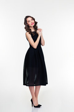 Full length of cheerful retro styled female in black dress
