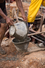 worker pouring concrete from pail bucket