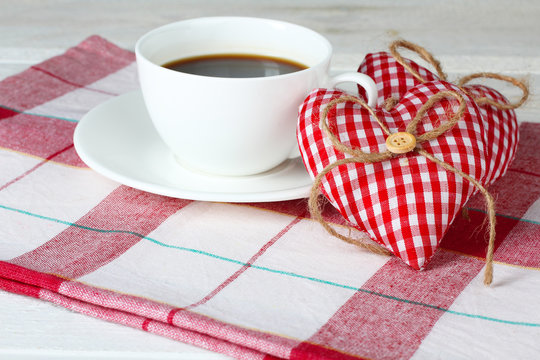 Decorative heart Valentine with a Cup coffee and saucer on a napkin  on wooden background