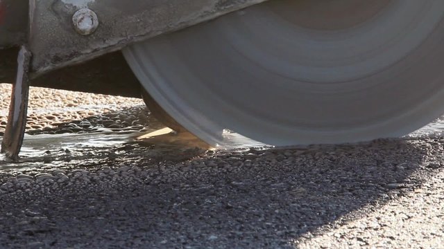Worker cutting asphalt road, close up