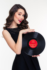 Portrait of attractive smiling retro styled woman holding vinyl record