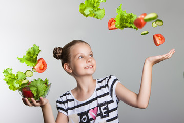 Beautiful smiling girl holding a plate with vegetables