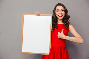 Woman holding blank board and showing thumb up