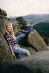 Naklejka premium Young beautiful couple in jeans and shirts for a walk in the mou