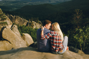 Naklejka premium Young beautiful couple in jeans and shirts for a walk in the mou