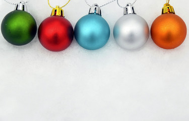 Colorful Christmas balls on snow background.