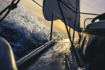 Segelboot fährt schnell bei Sonnenuntergang
