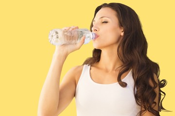 Composite image of brunette drinking water