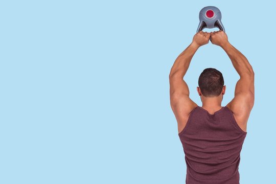 Composite image of muscular serious man lifting a kettlebell