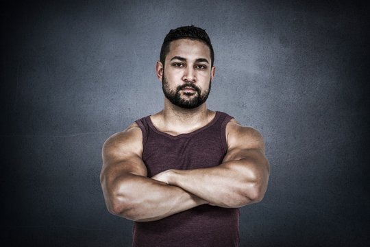 Composite image of muscular man looking at camera