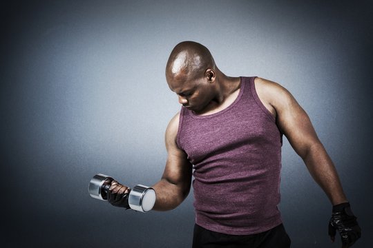 Composite image of fit man exercising with dumbbell 