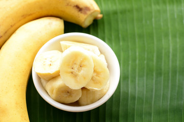 sliced banana in a cup over a table.