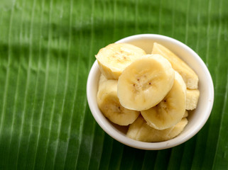 sliced banana in a cup over a table.