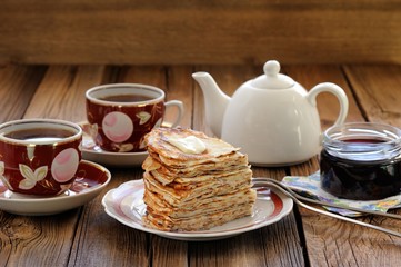 Russian pancakes in heap with jam and black tea