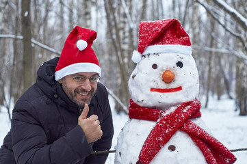 Happy man with a snowman in the park