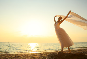 ballet dancer with a veil at sunset on the coast