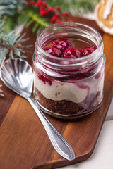 Layered dessert in a glass jar on a wooden table.