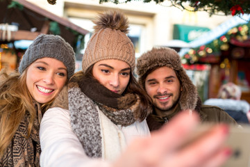 Freunde, Paar, Gruppe schiesst Selfie Foto auf dem Weihnachtsmarkt