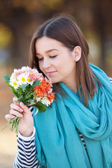 Naklejka premium Young woman with bunch of wildflowers