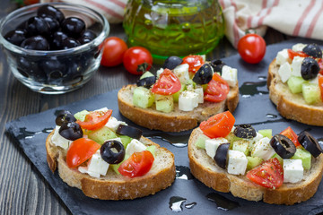 Greek style crostini with feta cheese, tomatoes, cucumber, olives and herbs