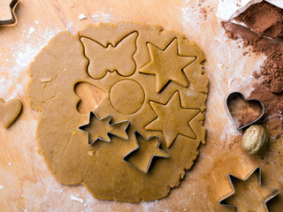 Cookies forms and gingerbread dough on wooden pastry board