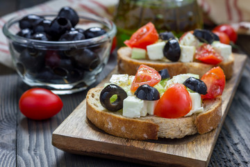 Greek style crostini with feta cheese, tomatoes, cucumber, olives and herbs