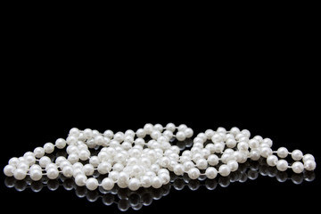 Perlenkette auf schwarzen spiegelndem Hintergrund