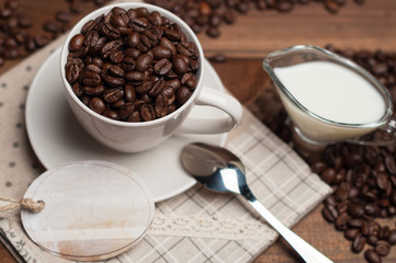 White cup of coffee and milk on wooden surface