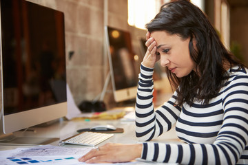 Stressed Female Designer Works At Computer In Modern Office