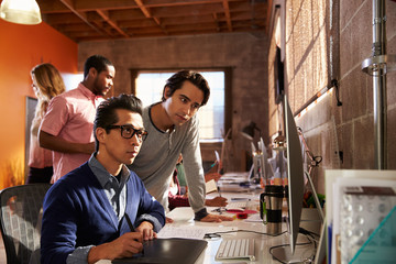 Designers Working At Desks In Modern Office