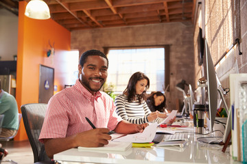 Team Of Designers Working At Desks In Modern Office