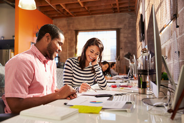 Obraz premium Designers Working Together At Desks In Modern Office