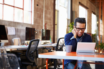 Designer Sitting At Meeting Table Working On Digital Tablet